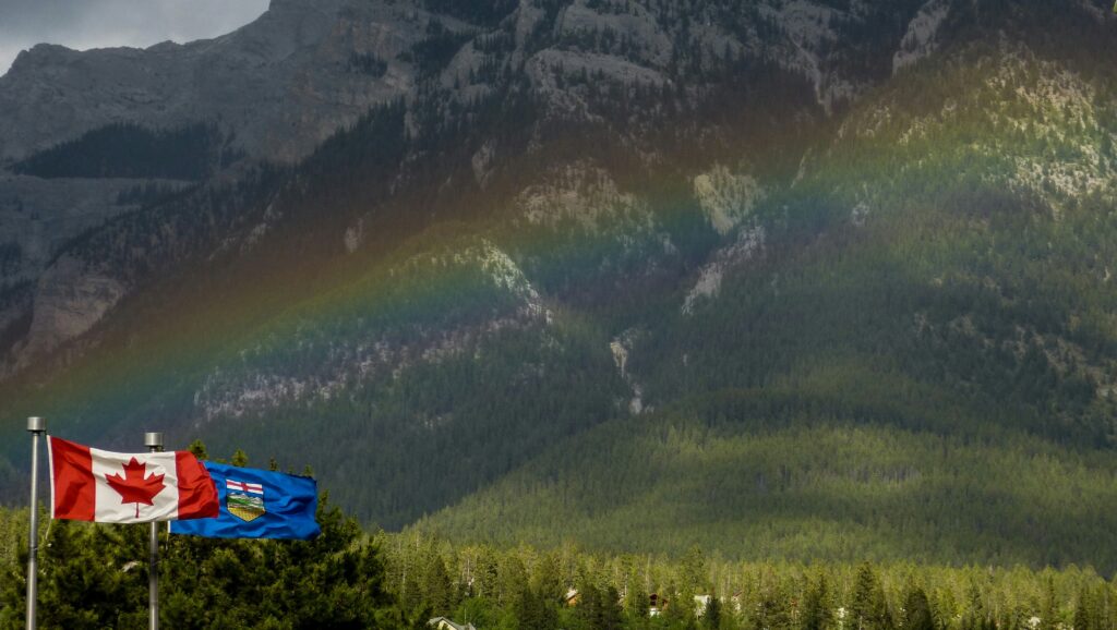 Alberta and Canada flags flying in the mountains