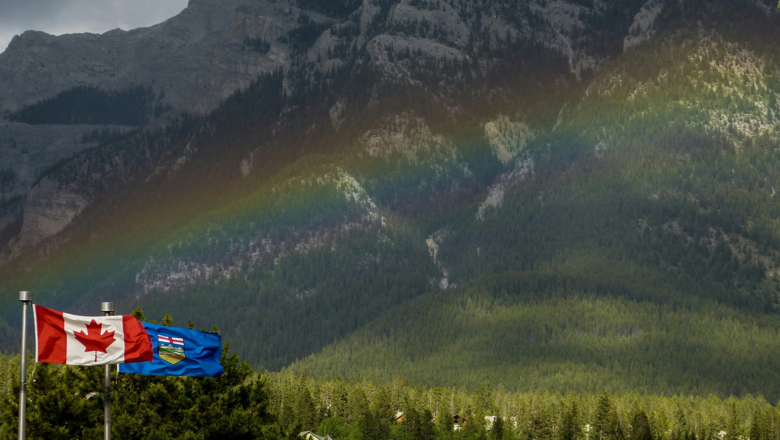 Alberta and Canada flags flying in the mountains