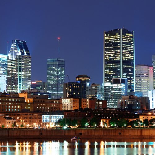 Montreal over river at dusk with city lights and urban buildings