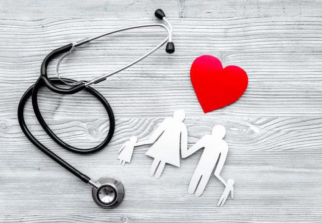 Choose health insurance. Stethoscope, paper heart and silhouette of family on grey wooden background top view.