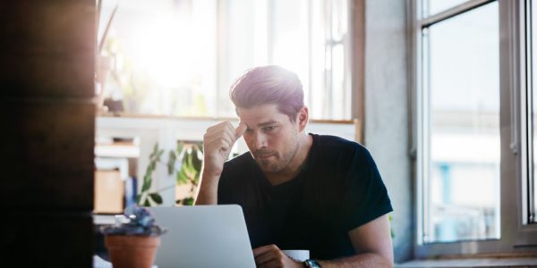 Business man thinking about a problem at his laptop